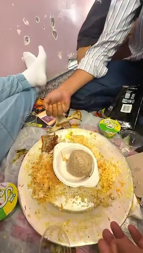 Gushtaba in a bowl of white yoghurt gravy set on the rice of a shared Wazwan trami at a Kashmiri wedding, near the end of the meal