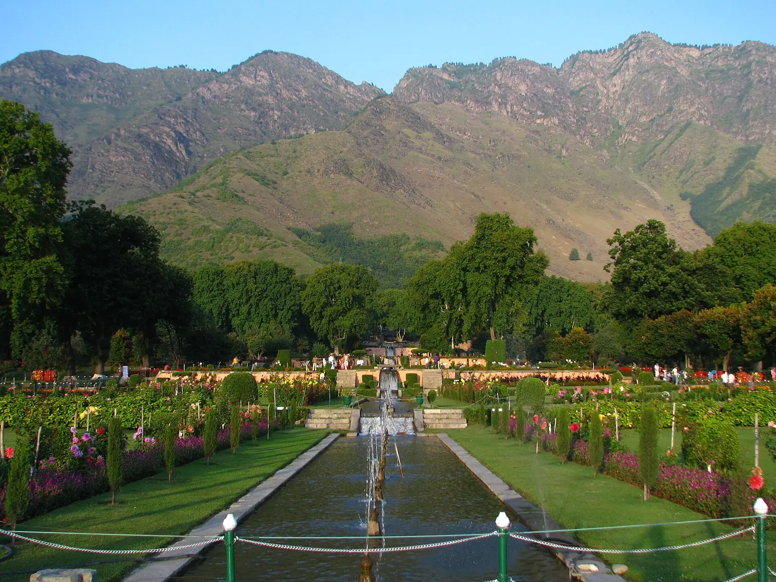 Terraced Nishat Bagh Mughal garden in Srinagar with a long water channel, flower beds and the Zabarwan hills behind