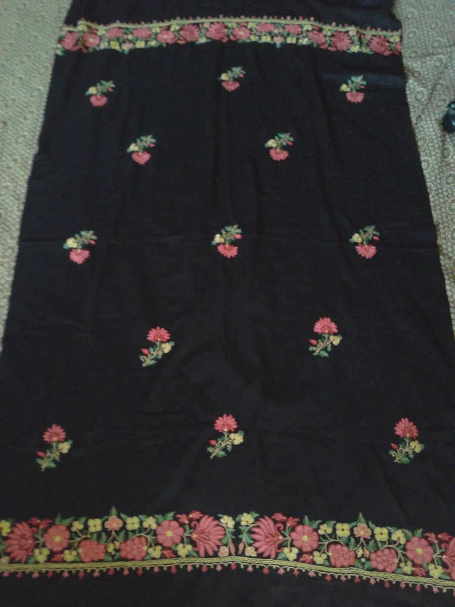 Black Kashmiri shawl with pink and yellow floral embroidery along the borders, laid out flat