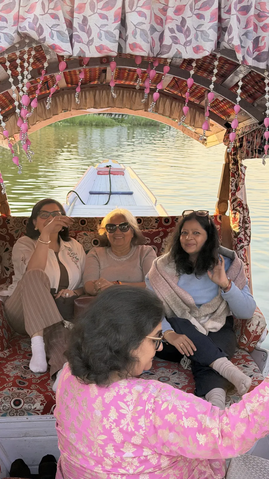 Women from our ladies group relaxing on cushions inside a decorated shikara on Dal Lake