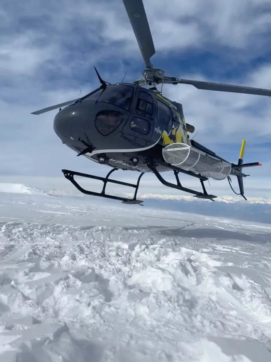 A helicopter touching down on fresh snow high above Gulmarg, from our reel